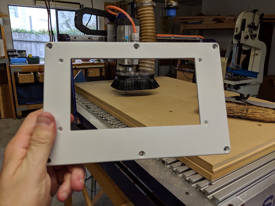 The lid with a hole for the screen drilled in it, in front of the CNC mill