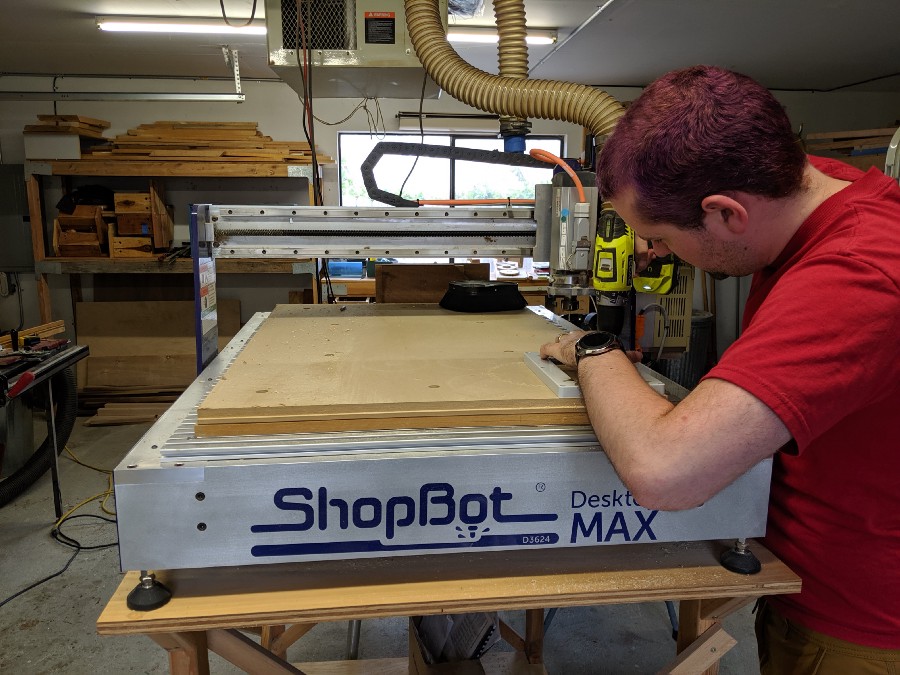 Randall securing the enclosure lid to the deck of a ShopBot Desktop Max CNC mill.
