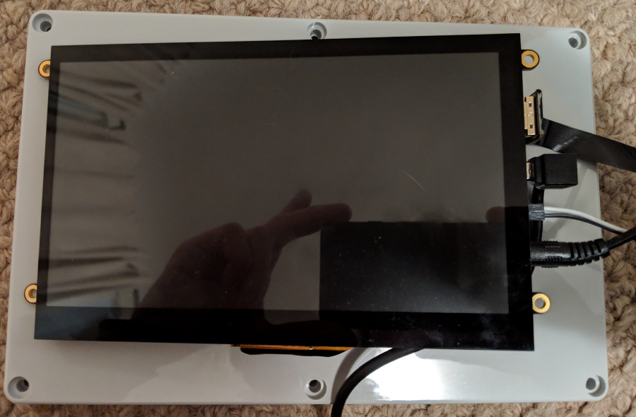 A test fit of the screen laid on top of the case lid, with several cables for HDMI, USB, PWM, and power attached to the right side of the screen