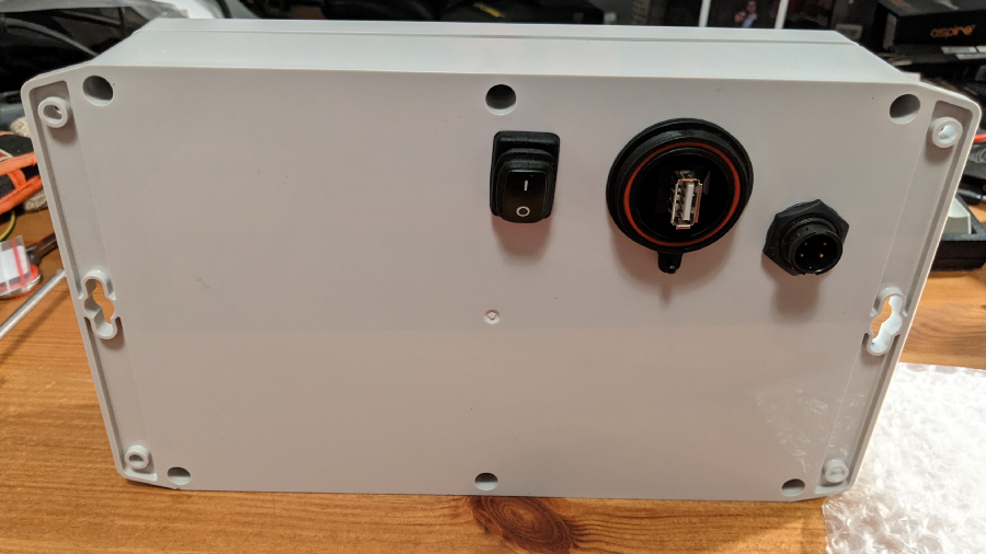 The rear of the device enclosure, with waterproof power switch, USB connector, and power cable connector