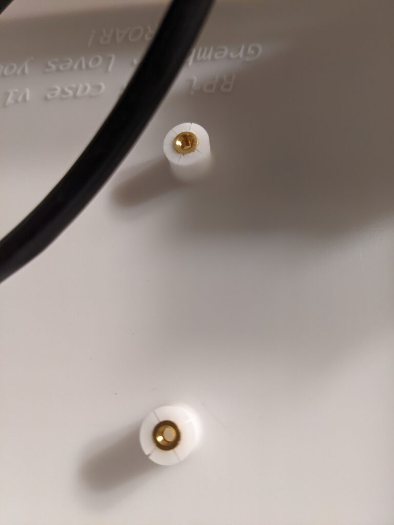 Close-up view of two mounting bosses for the Raspberry pi with heat-set inserts affixed
