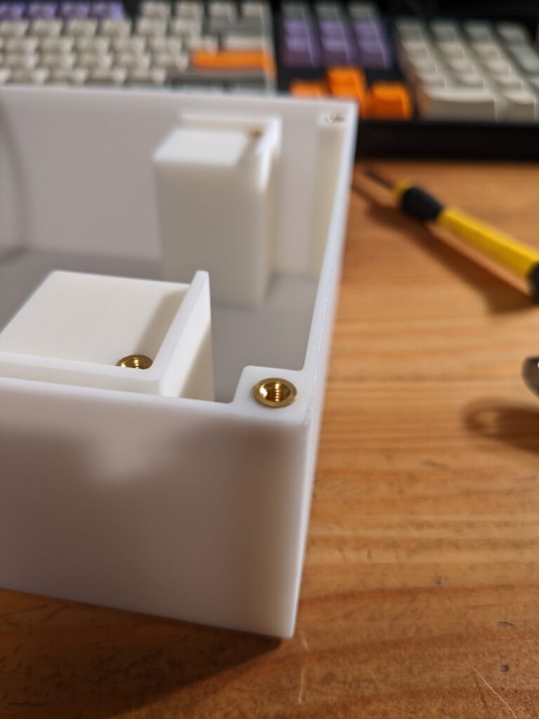 Close-up view of installed heat-set threaded insert in the corner of the case body, for attaching the lid.