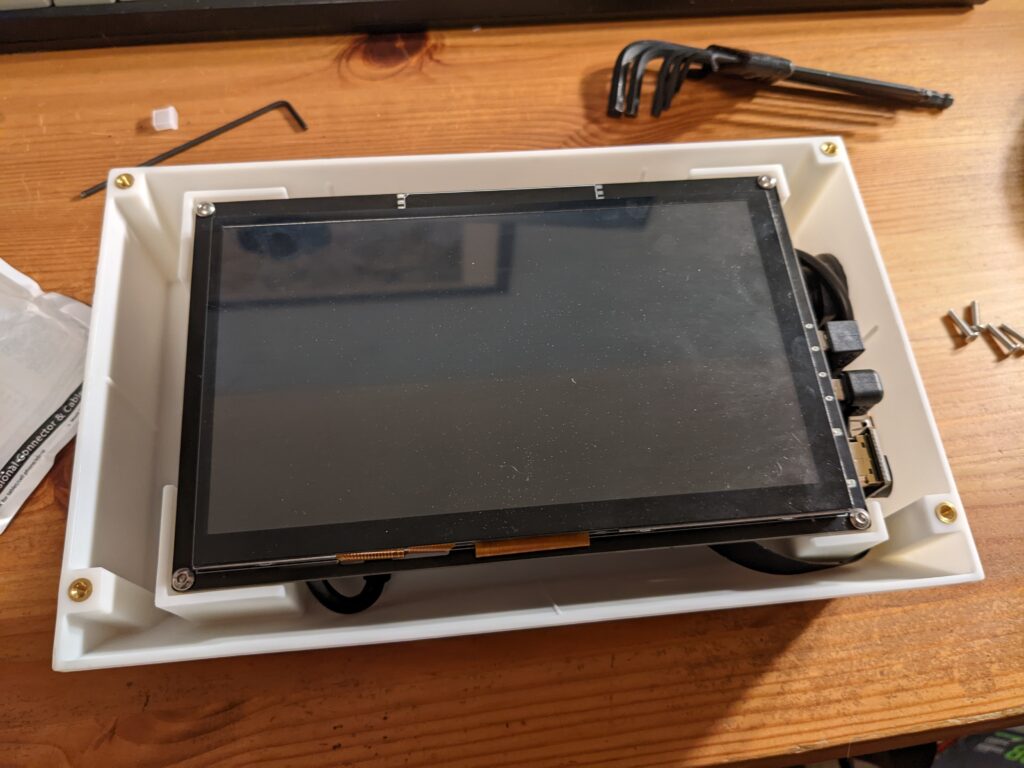 A 7" LCD touchscreen is screwed in to the case on top raised mounting pillars