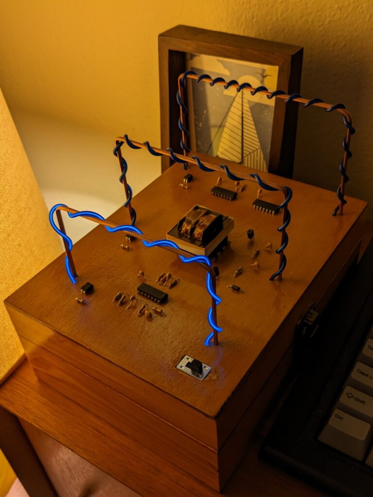 An electronic circuit on top of a wooden box, with illuminated wiring