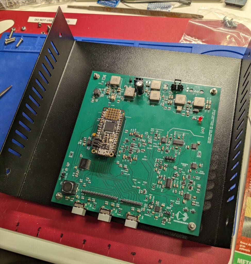 A PCBA (PCB with mounted components) is screwed into the bottom half of a project enclosure