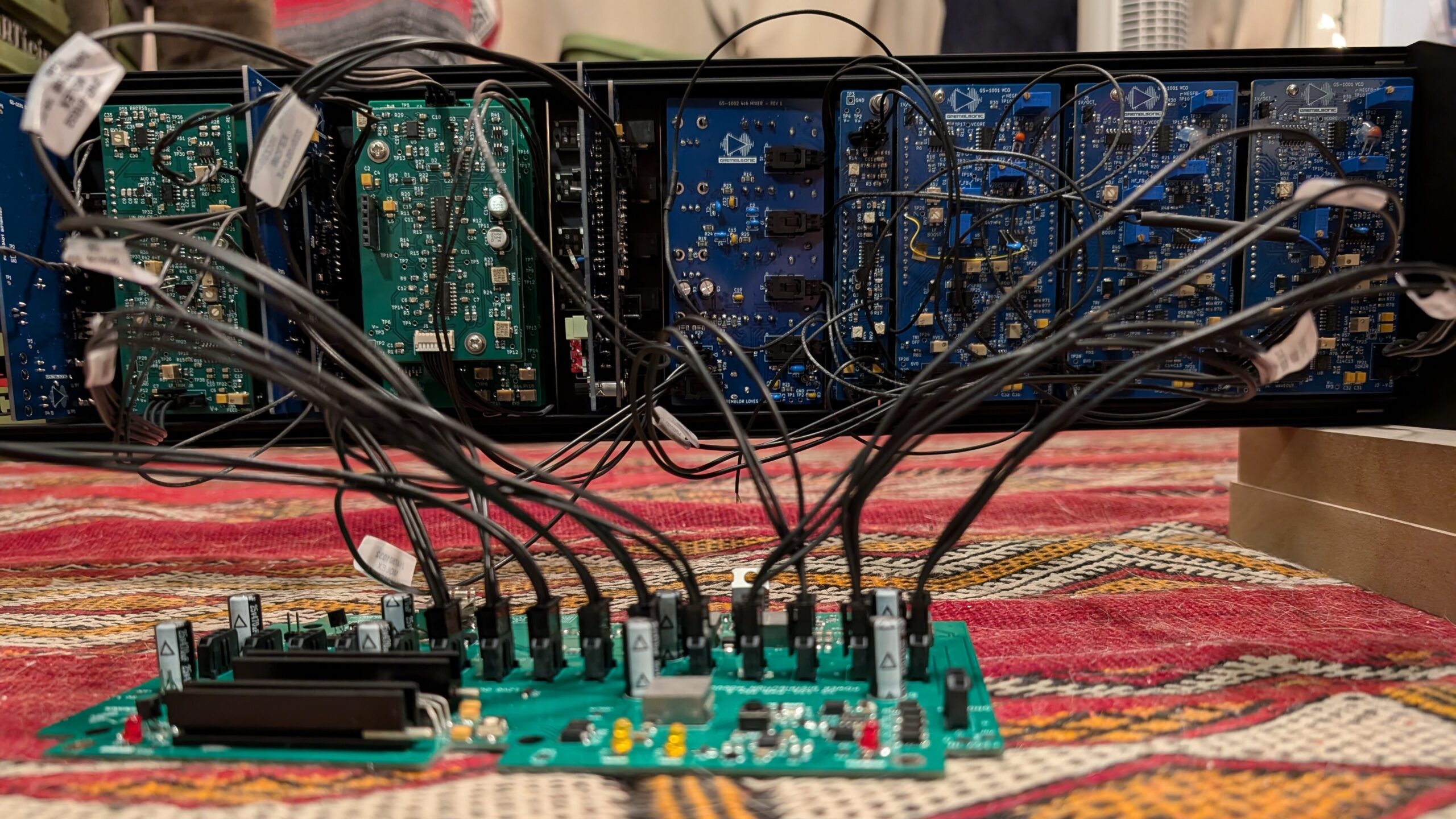 A collection of circuit boards mounted on rack rails, with a web of wiring connecting them to one another.